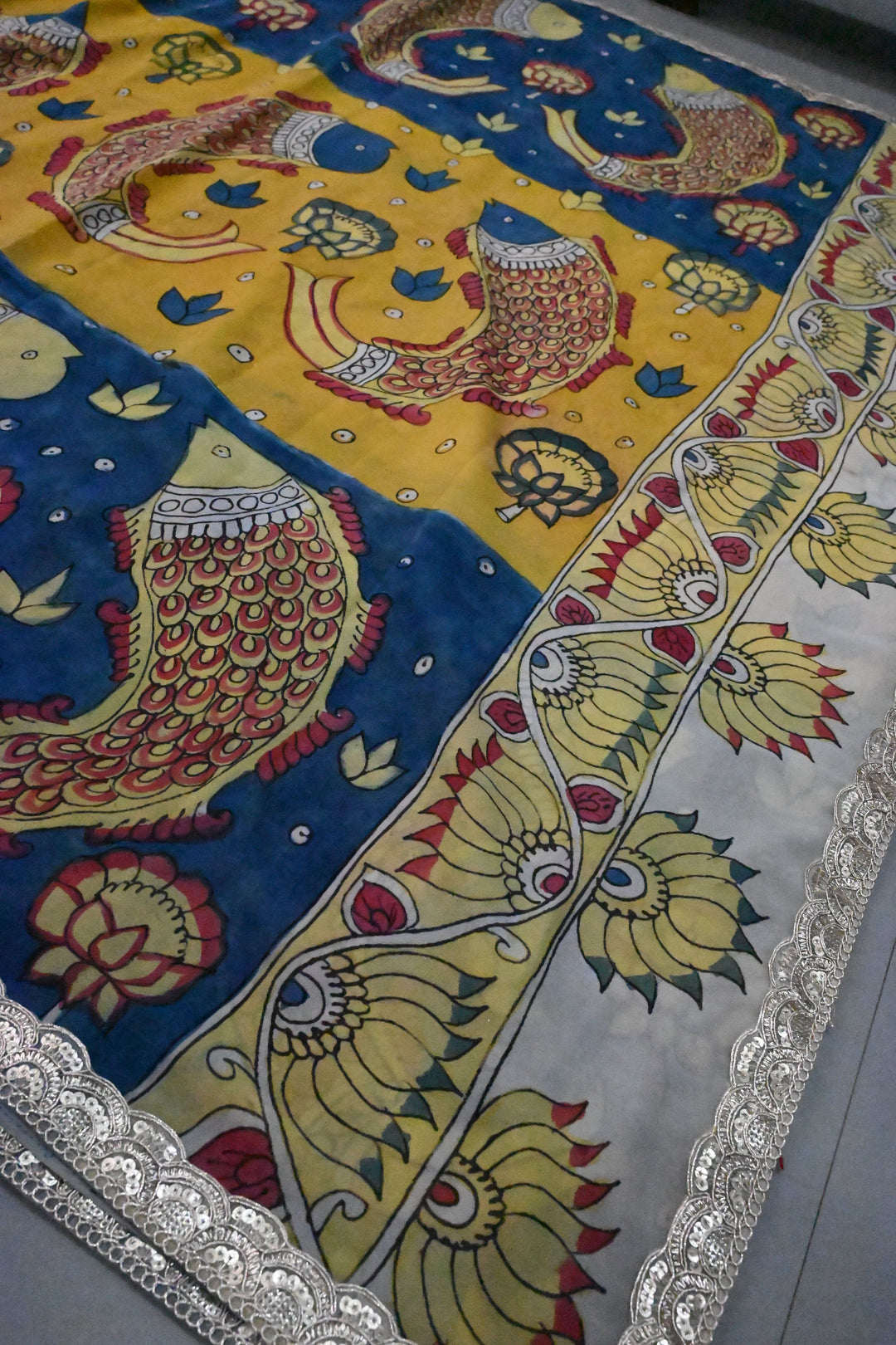Floral and Matsya Theme : Yellow and Blue Authentic Pen Kalamkari on Banarasi Pure Georgette Saree with Fancy Lace Border  | SILK MARK CERTIFIED | SHOBITAM
