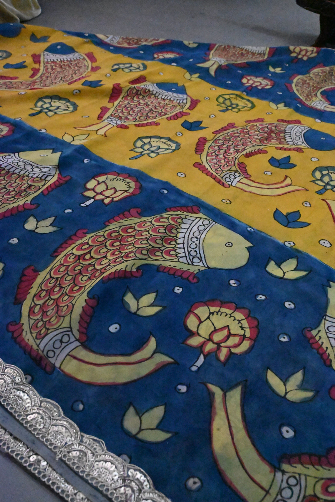 Floral and Matsya Theme : Yellow and Blue Authentic Pen Kalamkari on Banarasi Pure Georgette Saree with Fancy Lace Border  | SILK MARK CERTIFIED | SHOBITAM