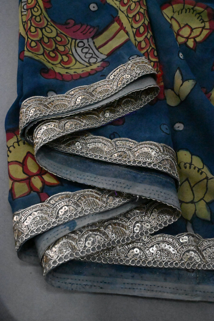 Floral and Matsya Theme : Yellow and Blue Authentic Pen Kalamkari on Banarasi Pure Georgette Saree with Fancy Lace Border  | SILK MARK CERTIFIED | SHOBITAM