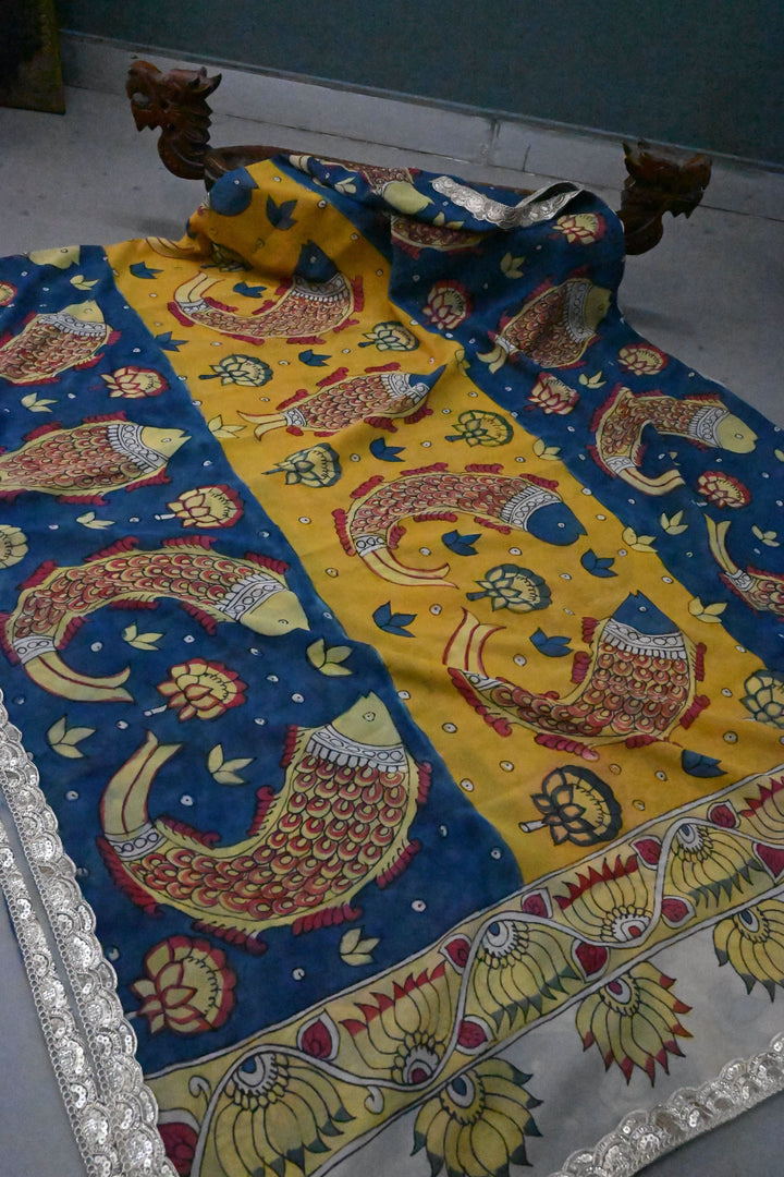 Floral and Matsya Theme : Yellow and Blue Authentic Pen Kalamkari on Banarasi Pure Georgette Saree with Fancy Lace Border  | SILK MARK CERTIFIED | SHOBITAM