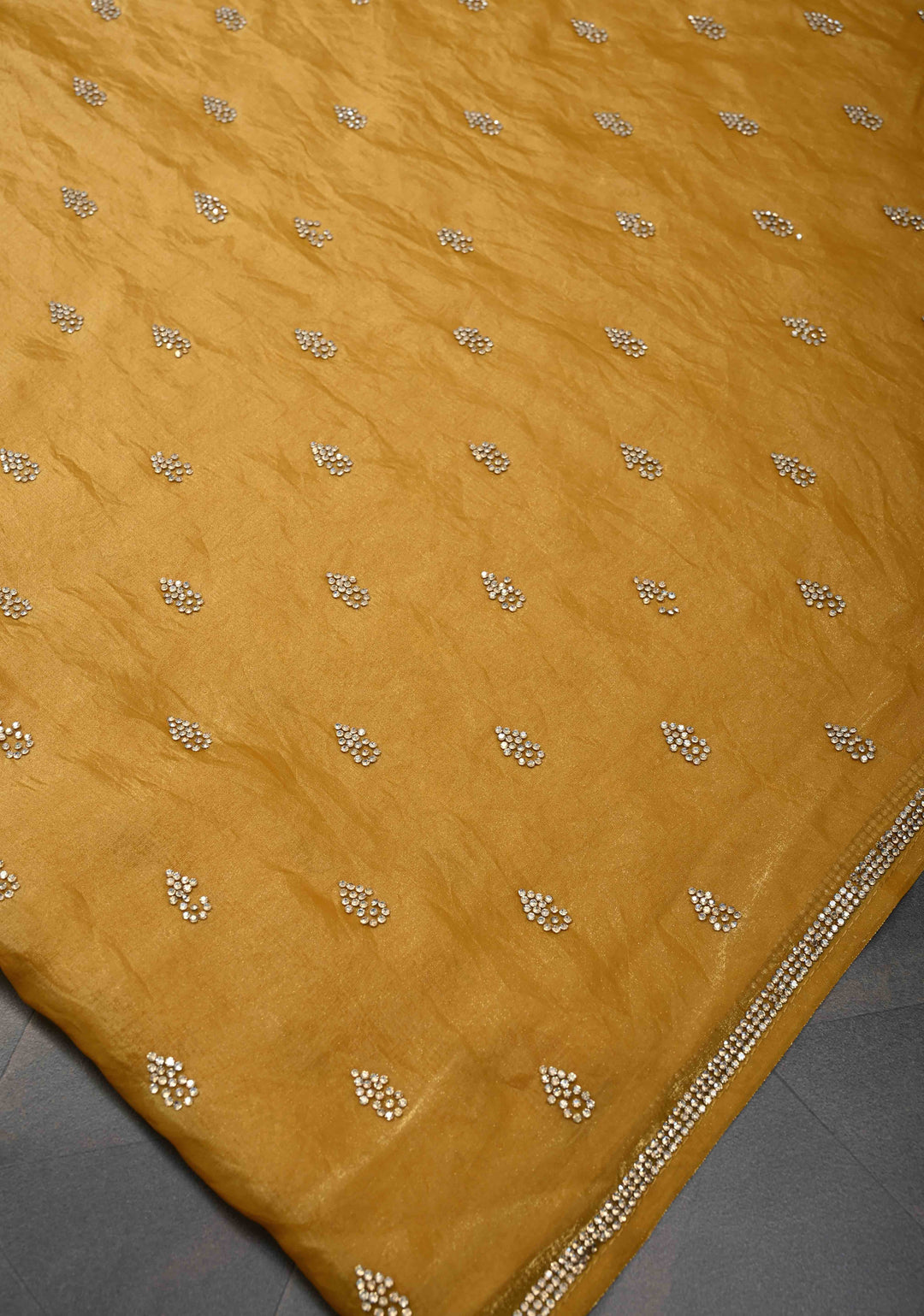 Ochre shimmer Georgette saree with stone buttas and minimal borders