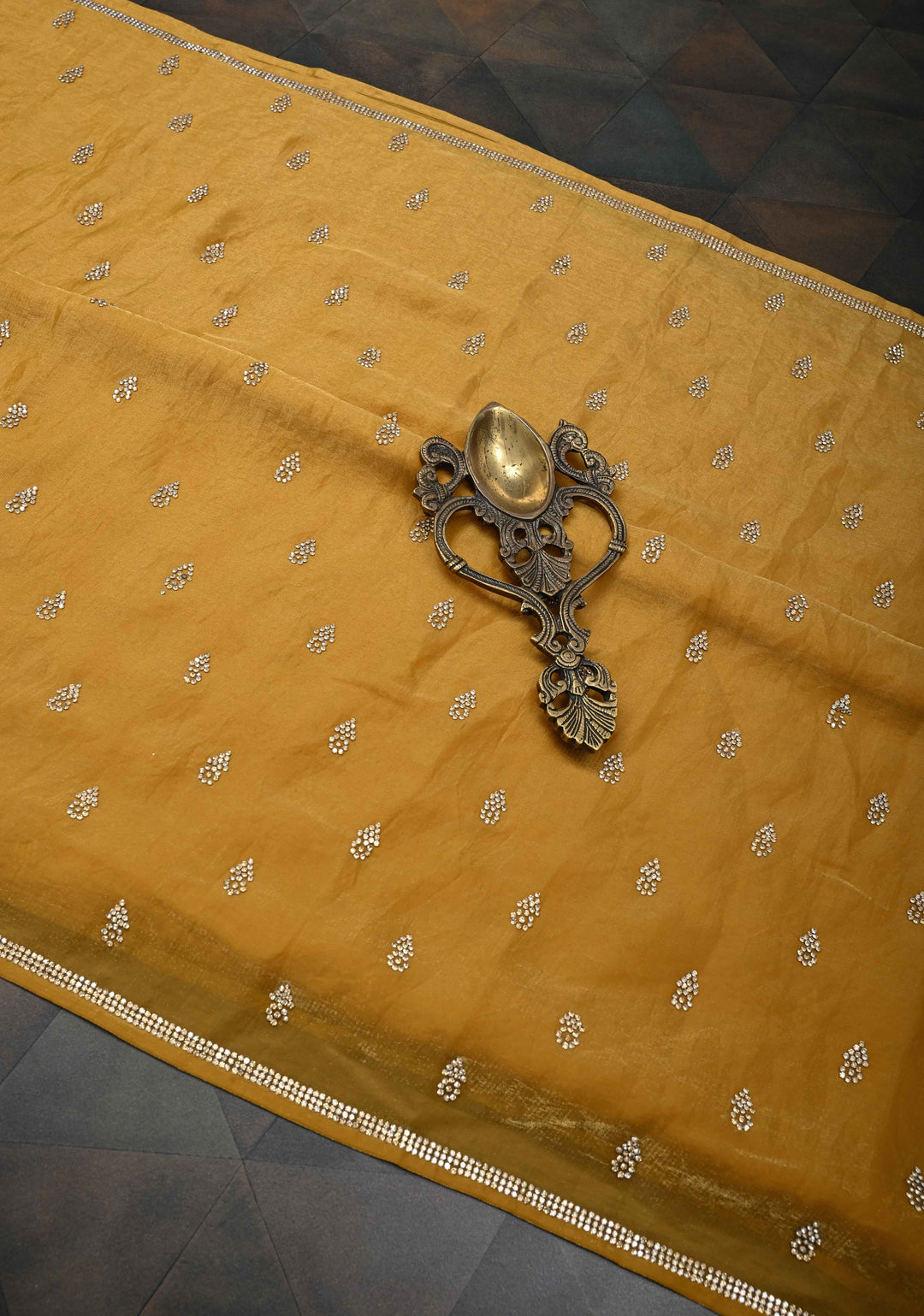 Ochre shimmer Georgette saree with stone buttas and minimal borders