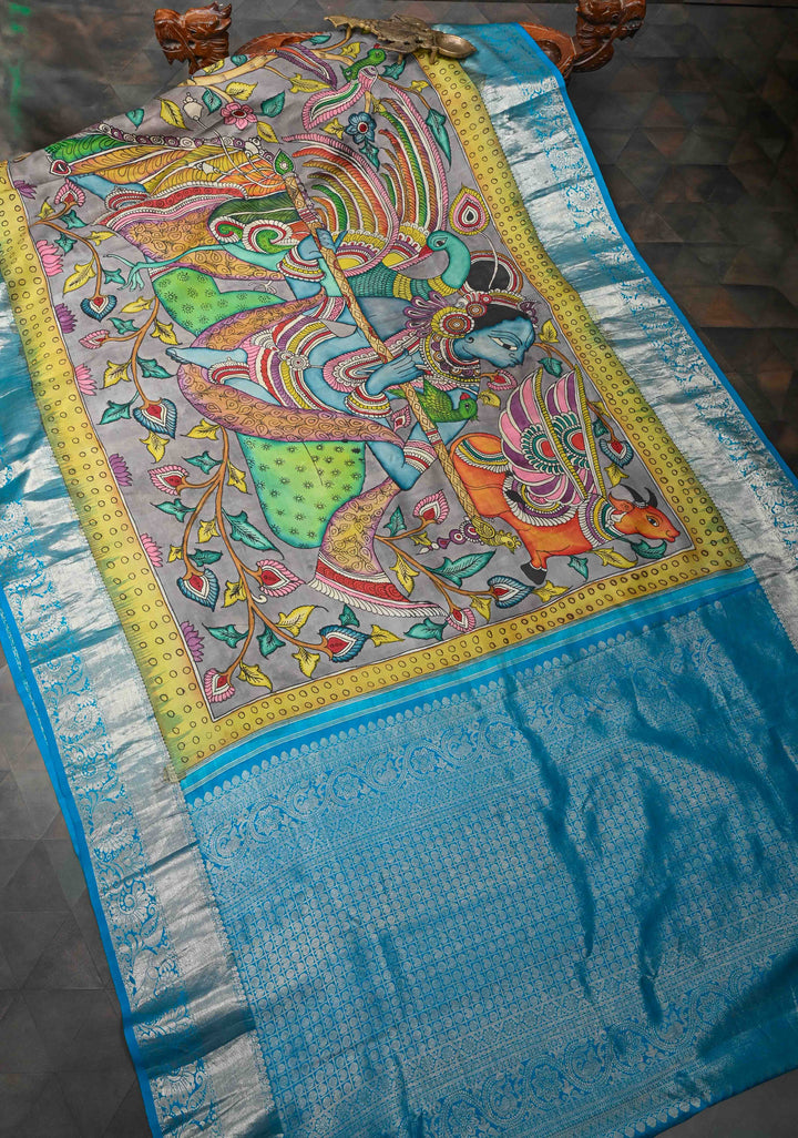 Krishna and Pichwai Theme :  Authentic Gray Pen kalamkari on Pure Kanjivaram Silk Saree with Azure Blue Contrast base Zari Border | SILK MARK CERTIFIED
