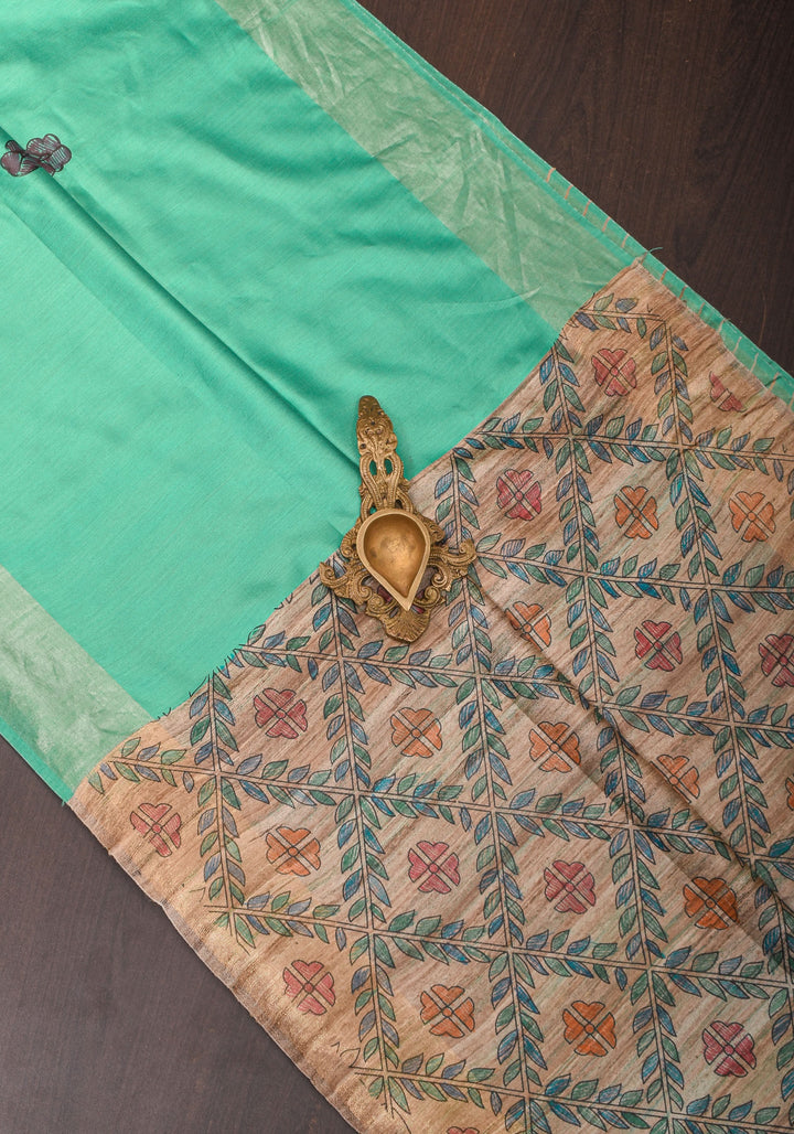 Sea Green Semi Tussar Silk, adorned with a Madhubani Hand painted Tussar Pallu and Zari Border